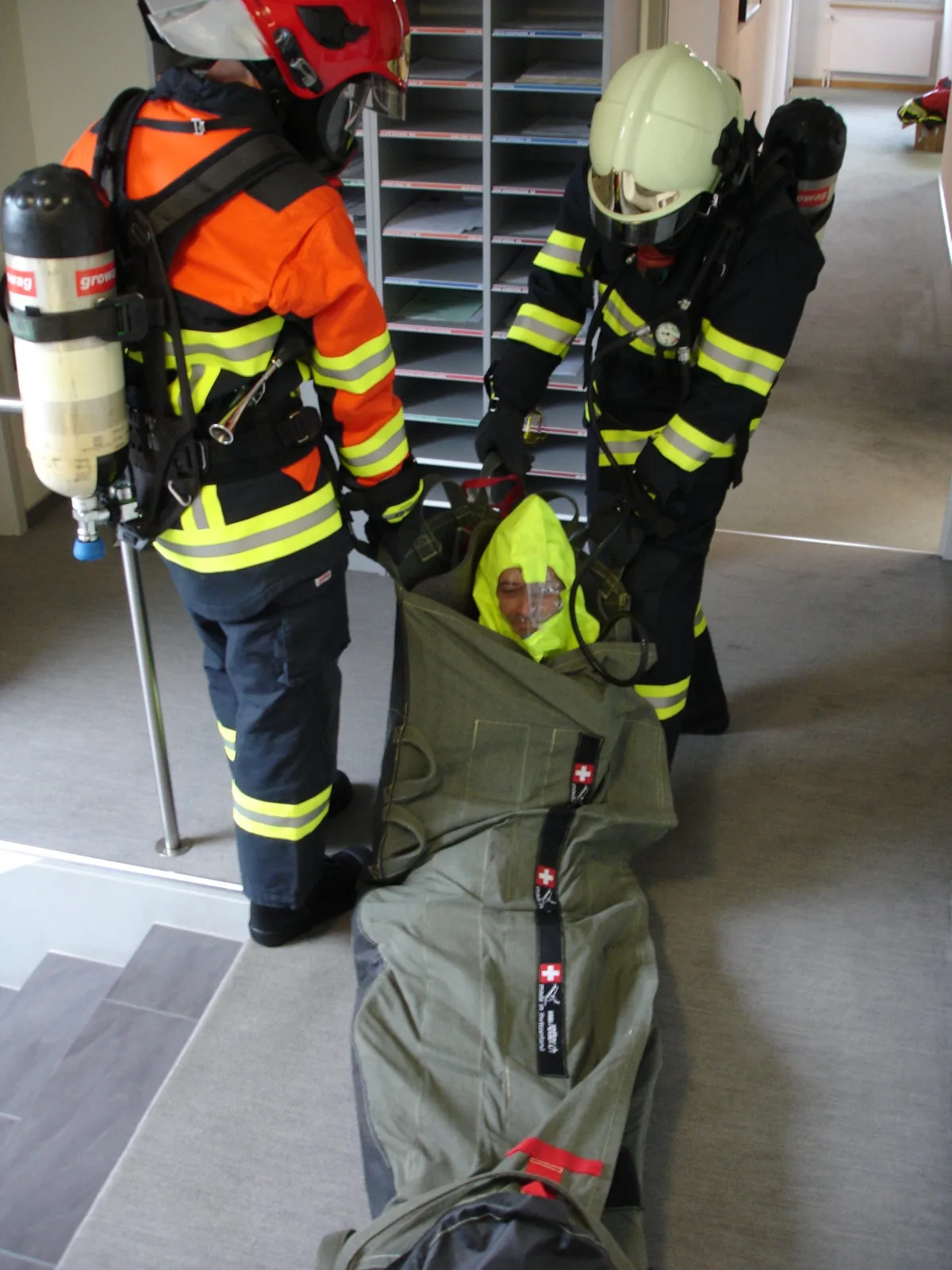 Zwei Feuerwehrleute unter Atemschutz machen den RescueBag S-2-S PRO im Treppenhaus einsatzbereit